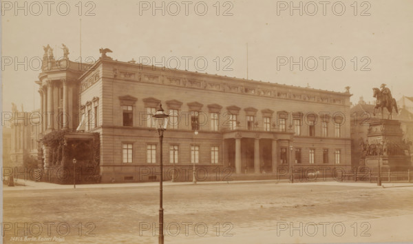 Kaiserlicher Palast, Berlin, Germany, photograph, Germany., check stamp: 'Frith's ...', inscription: '24955. Berlin, Kaiserl Palais.', inscription: 'Frith's', photographer: Francis Frith & Co., c. 1875 - c. 1900, paper, pasteboard, albumen print, height 158 mm, width 261 mm x width 370 mm, height 316 mm, A wide stone building with a decorated cornice and rows of tall windows occupies the center of the scene, featuring a columned portico at its entrance and sculptural reliefs along the upper frieze; a large equestrian statue on a multi-tiered pedestal stands to the right, surrounded by smaller sculpted figures and a low metal fence; ornate street lamps line the cobblestone street in front of the building, and a solitary lamppost is prominent in the foreground; architectural details include pedimented window surrounds, pilasters, and a rounded corner section with tall columns and statues on the roof; a carriage and horse are visible near the statue, and nearby buildings can be seen behin...