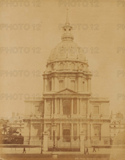 Hôtel National des Invalides ('Dôme des Invalides'), Paris, France, photograph, Frontal view of the Hôtel National des Invalides, located in the 7th arrondissement of Paris. It was founded in 1671 by Louis XIV., inscription: '108, Paris - Dôme des Invalides', check stamp: 'Photographic Company, J. Kühn, 220 170174 Rue de Rivoli', number: '16.', publisher: J. Kühn (publisher), c. 1885 - c. 1910, paper, pasteboard, albumen print, height 275 mm, width 218 mm x width 447 mm, height 326 mm, Dôme des Invalides, A large classical building facade with a tall ornate dome and a spire rising above it, featuring columns, arches, sculpted reliefs, and decorative balustrades, a fenced forecourt with stone pillars and lamp posts in front, several small human figures walking along the pavement, and portions of adjacent lower buildings and trees visible at the edges.