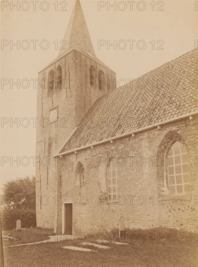 Tower of the former Reformed Church in Oosterwierum, photograph, annotation: 'Oosterwierum, Oosterwierum, gem. Baarderadeel', Toren a, d NH Kerk, Aug 1902, Baarderadeel', photographer: AJM Mulder (possibly), 1902, AJM Mulder, photographer, Attributed to, paper, pasteboard, albumen print, albumendruk, height 225 mm x width 168 mm, parts of church exterior and annexes: tower, A stone church building with a tall square tower topped by a pointed spire, arched openings in the tower, a clock face on the tower wall, a steep tiled roof extending from the tower, tall arched windows set in the brick wall, a doorway at the base of the tower, patches of grass and a few grave markers near the building, and some trees visible at the edge of the scene.