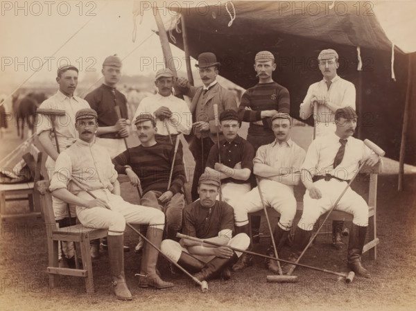 Polo players, Abbottabad, Khyber Pakhtunkhwa, Pakistan, album page, photograph, Group portrait of polo players, Pakistan. The men are sitting and standing partly under a tarpaulin., number: '1560', title: 'Polo Players Abbottabad 1885', 1885, photographer, pasteboard, paper, albumen print, height 207 mm x width 281 mm, height 264 mm x width 347 mm, A group of men posed in front of a tent, wearing a mix of light and dark shirts, jackets, and caps, many with mustaches and short hair, some seated on wooden chairs or benches and others standing behind; several men hold long wooden mallets and sticks across their laps or resting on the ground, while one man in a bowler hat stands with an arm raised on a pole supporting the tent; the tent fabric hangs overhead with visible ropes and ties, and the grassy ground beneath shows scattered mallet heads and the lower legs of the seated men in tall boots.