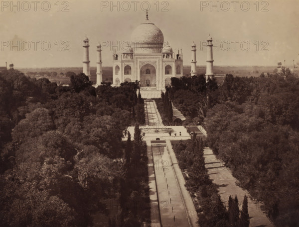 View of the Taj Mahal with trees on the foreground, Agra, Uttar Pradesh, India, photograph, Taj Mahal, India., title (): 'Agra. The Taj', number (false): '23', c. 1875 - c. 1900, photographer, paper, albumen print, height 208 mm x width 274 mm, North India, A large white marble mausoleum with a central domed chamber flanked by four tall minarets stands at the far end of a long formal garden axis, visible from an elevated perspective; the mausoleum shows arched entrances and decorative inlaid panels on its façade, and low domed kiosks at its corners. A long straight water channel and paved walkway lead from the foreground toward the building, lined on both sides by rows of slender trees and broader stands of dense foliage. The surrounding landscape is filled with many trees and gardens, and low structures and distant flat land appear beyond the central monument. The image has a muted, sepia-toned appearance and an overall vintage photographic quality.