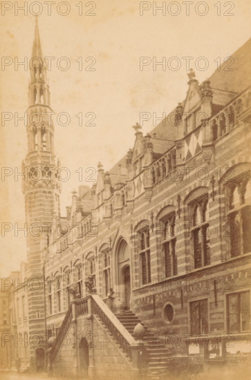 Hotel de Ville d'Alkmaar, Exterior of the Alkmaar Town Hall, photograph, Alkmaar, c. 1865 - c. 1880, photographer, paper, pasteboard, albumen print, height 147 mm x width 97 mm, town hall, façade (of house or building), Town Hall (Alkmaar), A sepia-toned photograph of a large ornate stone building with striped masonry and arched windows, featuring an exterior staircase with stone balustrades leading up to an arched entrance flanked by sculpted figures; the façade shows decorative gables and window tracery, triangular flags hanging from the upper level, and sculpted finials along the roofline; a tall, intricately carved tower with openwork sections rises beside the building, and rows of windows and masonry details extend along the street-level façade.