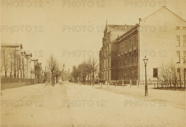 View of the Plantage Middenlaan with the St. Jacobsgesticht on the right and the Muiderpoort in the background in Amsterdam, Amsterdam, cabinet photograph, annotation: 'Plantage (?)', collector's mark: 'VOSMAER', number: '92', Plantage Middenlaan, publisher: Andries Jager, 1860 - 1890, Andries Jager, photographer, publisher, Plantagebuurt, paper, pasteboard, albumen print, albumendruk, height 94 mm x width 136 mm, height 108 mm x width 168 mm, street, lunatic asylum, mental home, city-gate, Tweede Muiderpoort, Sint-Jacobsgesticht, A wide sepia-toned street scene shows a broad empty roadway flanked by rows of leafless trees and sidewalks, with a tall ornate multi-story brick building on the right featuring many tall windows and decorative architectural details, and a large plain-faced building adjacent to it with a lamppost in front; on the left a fenced line of lower classical buildings with columned facades and similar leafless trees runs parallel, and a domed structure is visible in ...