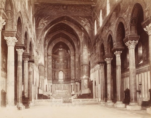 Monreale Sicily, Interior of the cathedral in Monreale, Sicily, photograph, inscription: ''19.173', number: '134', stamp: 'R: MVS.', photographer: Giorgio Sommer, Monreale, 1857 - 1914, Giorgio Sommer, photographer, pasteboard, paper, albumen print, height 314 mm x width 444 mm, interior of church, Cathedral of Monreale, A wide interior view of a church nave showing tall stone columns with ornate carved capitals supporting a series of arches along both sides, frescoed walls and vaulted ceilings decorated with religious paintings and circular medallions, a central apse with a large painted figure above a smaller row of painted figures and a tall arched window, an elevated altar area with steps, candlesticks and a carved altar frontal, wooden choir stalls and pulpit along the sides, patterned marble or stone flooring in the foreground, decorative panels and geometric designs on lower walls, and various small furnishings like chairs, a lectern and candle holders placed near the columns an...