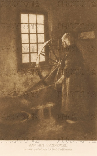Woman by a spinning wheel, At the spinning wheel, page, photomechanical print, inscription: 'after a gum print by CA Deul Jr. in Hilversum.', photographer: Cornelis Albertus Deul, Netherlands, clichémaker: anonymous, c. 1900 - in or before 1905, paper, photoaquatint, height 167 mm x width 118 mm, Title page with subtitle is actually missing: subtitle will be the same for first, second, third and fifth series, farmers - AA - female farmer, farmer's wife, spinning-wheel, female sex, woman, A sepia-toned scene shows a person standing beside a large wooden spinning wheel near a window with multiple panes; the person wears a hooded garment and holds a distaff with both hands while gazing toward the wheel, and soft light from the window casts subtle shadows across a textured interior wall and floor.