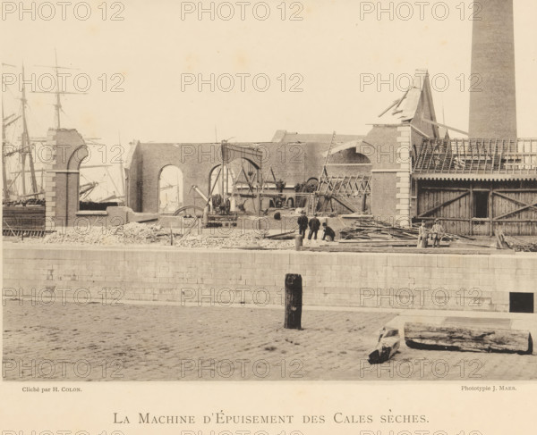 View of a machine in the remains of a munitions factory that exploded in Oosterweel near Antwerp in 1889, La machine d'épuisement des cales sèches, page, photomechanical print, number: '6', photographer: Henri Colon, Oosterweel, cliché maker: anonymous, Belgium, printer (person): J. Maes (possibly), Antwerp, publisher: J. Maes, 1889, Henri Colon, J. Maes, photographer, cliché maker, printer (person), publisher, paper, collotype, light printing, height 165 mm x width 230 mm, Image on page 6., ruin of a building, architecture, machines, parts of machines, tools and appliances, Explosion of a munitions factory in Oosterweel in 1889, A wide sepia-toned scene of a waterfront construction area shows a partially built or demolished brick structure with large arched openings and exposed wooden beams, adjacent to a tall cylindrical chimney. Scattered piles of rubble and stacks of timber lie along the quay in front of the building, where scaffolding, ladders, and construction machinery with visi...