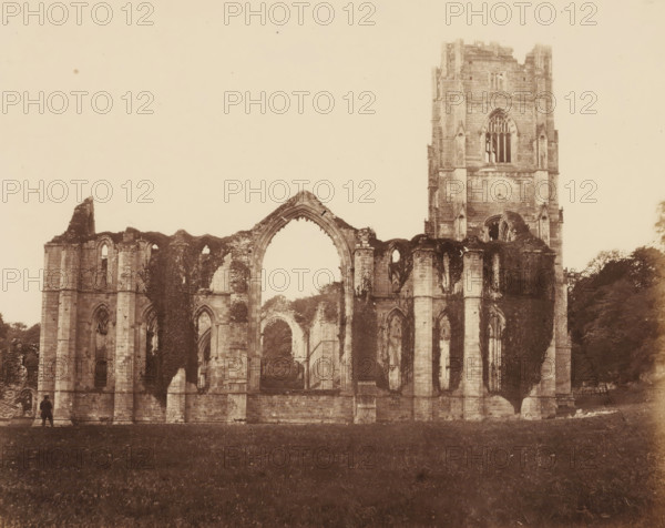 View of the Chapel of the Nine Altars at Fountains Abbey near Ripon, photograph, page, photographer: Joseph Cundall, Fountains Abbey, photographer: Philip Henry Delamotte, c. 1851 - in or before 1856, Yorkshire, Studley Royal Park, paper, albumen print, height 227 mm x width 279 mm, parts of church interior: chapel, ruin of church, monastery, etc. - QQ - small church, A sepia-toned photograph of a large stone ruin with tall arched openings and a partially intact tower on the right, showing worn masonry, columns, and tracery windows, with ivy or vegetation growing on parts of the structure and trees visible behind and to the right, and a grassy foreground with a small solitary figure standing near the left edge of the ruin.