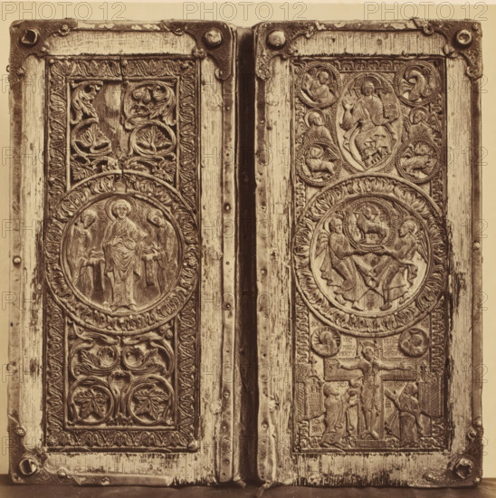 Ivory diptych with depictions from the New Testament, from the Cathedral of Our Lady in Tournai, displayed at an exhibition of religious objects from the Middle Ages and Renaissance in 1864 in Mechelen, photograph, page, number: '4', photographer: Joseph Maes, Mechelen, 1864, paper, albumen print, height 198 mm x width 199 mm, New Testament, piece of sculpture, reproduction of a piece of sculpture (bone, ivory, arts), Period, A close-up view of two adjacent carved wooden panels with metal corner brackets and hinge between them, each panel featuring circular medallions with relief figures and ornate foliage motifs, framed by carved borders and vertical wood grain, with visible wear and small round rivets along the edges.