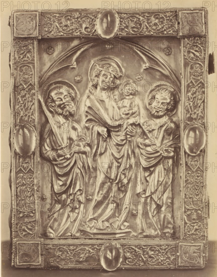 Book binding with Mary and Child and Peter and Paul from the Basilica of Our Lady in Tongeren, displayed at an exhibition on religious objects from the Middle Ages and Renaissance in 1864 in Mechelen, photograph, page, number: '15', photographer: Joseph Maes, Mechelen, 1864, paper, albumen print, height 240 mm x width 185 mm, book-cover, binding, Mary standing (or half-length), the Christ-child sitting on her arm (Christ-child to Mary's left), Period, A rectangular metal relief panel with an ornate border showing floral and figured decorative motifs surrounds a central scene of three robed figures under an arched framing element; the central figure wears a halo and holds a small seated child, while the two flanking figures also wear halos and hold objects in their hands; the border contains oval cabochon-like elements and numerous small carved scenes and vegetal patterns, and the surface displays highlights and shadows that accentuate folds in the drapery and facial features.