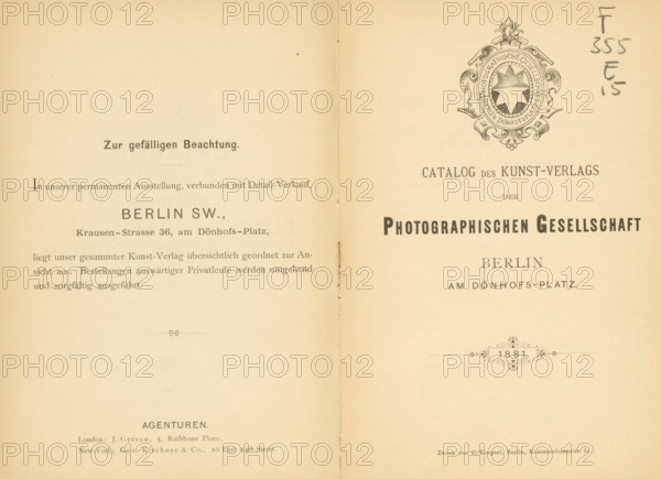 Catalog des Kunstverlags der Photographischen Gesellschaft Berlin 1881, book, name: 'Henri Hymans, Bruxelles', writer (clerical worker): various manufacturers, printer (person): C. Koepsel, Berlin, 1881, writer (clerical worker), printer (person), paper, albumen print, height 191 mm x width 130 mm x thickness 10 mm, The image shows an open two-page spread of an old printed catalog with a vertical fold down the center and aged beige paper; the right page features an ornate circular emblem near the top with decorative flourishes and a central star-like shape, while both pages display multiple lines of printed layout elements and ornamental horizontal dividers; there are small stains and spots on the paper and a handwritten pencil annotation near the top right edge, and the overall appearance includes slight discoloration and wear along the center fold and edges.
