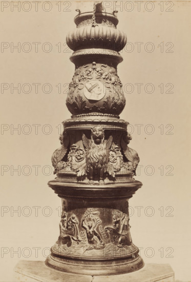 Relief-decorated column, photograph, photographer: attributed to Carlo Naya, c. 1880 - c. 1900, Attributed to, pasteboard, paper, albumen print, height 358 mm x width 272 mm, height 650 mm x width 500 mm, A tall ornate column segment with a rounded top section featuring fluted and beaded molding, a central bulbous urn-like form decorated with floral motifs and a raised circular medallion showing a profile of a human head, and a lower band with sculpted winged lion figures and elaborate foliage; beneath that a cylindrical base carved with relief scenes of human figures in dynamic poses among waves and leafy ornamentation, all rendered in a uniform stone or metal material against a plain light background.