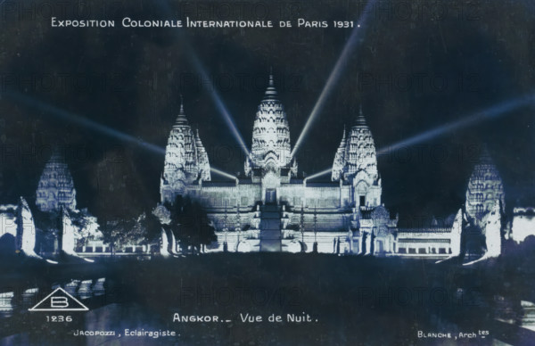 Exposition Coloniale Internationale de Paris 1931. Angkor - Vue de Nuit, View of the reconstructed temple city of Angkor at the Colonial Exhibition of Paris in 1931, at night, photograph, picture postcard, negative number: 'B 1236', Paris, publisher: Adolphe Braun & Cie., France, c. 1931-05 - c. 1931-11, photographer, paper, gelatin silver print, developing gelatin silver print, height 90 mm x width 137 mm, world fair, world exhibition, World Exhibition 1931 (Paris), A nighttime scene of an illuminated temple complex with a central stepped entrance flanked by ornate towers and smaller structures, bright spotlights casting beams upward and outward from the temple, reflective water or dark foreground in front of the complex, silhouetted trees and sculptural forms at the base of the temple, and a dark sky above.