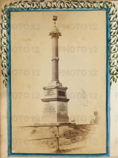 HMS Chesapeake memorial in Southsea, album page, photograph, Monument: HMS Chesapeake memorial in Southsea. Photo on an album page in an album with 68 photos, mostly with watercolor border decorations. They are mainly portraits in carte-de-visite format., England, 1865 - 1867, photographer, paper, paint (coating), pasteboard, watercolor (paint), albumen print, aquarelle, albumen print with painted border, height 160 mm x width 120 mm, statue, Portsmouth, Southsea, A tall stone column topped with an ornate capital and a decorative finial rises from a square pedestal with inset panels, set behind a metal railing and standing on a slightly sloped grassy surface; a person wearing a hat and coat stands near the right edge facing the monument, and a small boat is visible on the water in the background; the scene is bordered by a painted frame featuring blue inner lines and a leafy circular pattern along the top and sides.