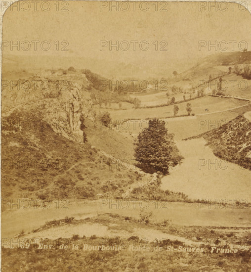 View of the cornfields between rocks in the vicinity of La Bourboule, France, Env. de la Bourboule, Route de St. Sauves. France, Views and landscapes in Europe, Africa and Asia, Geographical Sculpture Gallery, collected by MJ Broekhuijsen, Headmaster of a school in Amsterdam, stereograph, Bottom left of photo numbered: 69., annotation: 'La Bourboule and St. Sauves: seaside resorts in Auvergne, southwest of Clermont, on the Dordogne., Granite rocks on the left and right of the image. Cornfields in between.', La Bourboule, publisher: Merkelbach & Co., Amsterdam, compiler (person in literature): Martien Johan Broekhuijsen, c. 1905, photographer, compiler (person in literature), pasteboard, paper, albumen print, height 89 mm x width 178 mm, Part of a group of 52 stereophotos used in primary education as a supplement to school charts. The entire series consisted of 274 items in 10 categories (A to K)., landscapes in the temperate zone, A sepia-toned landscape photograph shows rolling hills ...