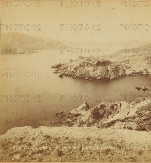 Cartagena. Entrance to the port, prise de Trinca Botijas, View of the entrance to the port of Cartagena, Spain, Views and landscapes in Europe, Africa and Asia, Geographical Sculpture Gallery, collected by MJ Broekhuijsen, Head of a school in Amsterdam, stereograph, Bottom left of photo numbered: 2814., annotation: 'Cartagena, great naval port, one of the best ports of the Mediterranean., The city lies entirely in the background, a good half hour away from us. At the entrance to the port, on the left on a 300 M. high hill, the Château de Galeras, on the right flat, by the sea, the Fort St. Anna, both for the protection of the port., Two breakwaters, one near the Château de Galeras, one to the right on the other side and, further away from us. The entire harbor is 600 HA in size (= as large as . . . . .)', Cartagena (Spain), publisher: Merkelbach & Co., Amsterdam, compiler (person in literature): Martien Johan Broekhuijsen, c. 1905, photographer, compiler (person in literature), pastebo...