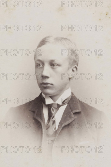 Portrait of a young man, album page, photograph, carte-de-visite, This photo is part of an album., inscription: 'JC REESINCK, ZUTPHEN, BERKELKADE B. 300., The printing plate is kept for reordering.', photographer: Johan Christiaan Reesinck, Zutphen (city), 1863 - 1900, paper, pasteboard, albumen print, height 83 mm x width 52 mm, historical persons, A head-and-shoulders portrait of a young person with short, light-colored hair, looking slightly to the side with a neutral expression, wearing a dark jacket over a high-collared shirt and a patterned necktie, shown against a plain, lightly speckled background.