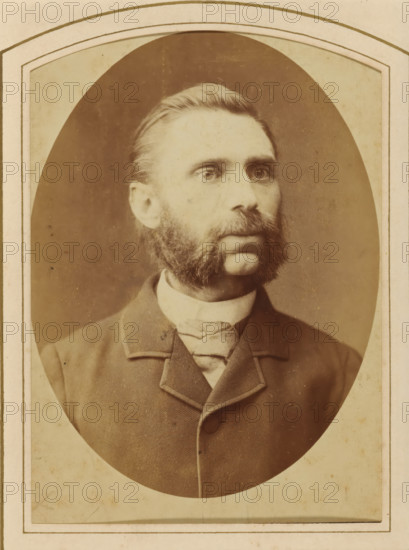 Portrait of a man, identified as Pa Heijnen, album page, photograph, cabinet photograph, This photo is part of an album., inscription: 'Artistic Photography, by, PW Roemer, Passage No 22, near Spuistraat., The Hague., Specializing in Enlargements., The plate is kept for reordering.', annotation: 'Pa Heijnen', photographer: Pieter Wilhelmus Roemer, The Hague, 1864 - 1910, paper, pasteboard, albumen print, height 137 mm x width 97 mm, historical persons, beard, A sepia-toned oval portrait of a man wearing a dark jacket with a high collar and a light-colored necktie, showing his head and upper torso against a plain background; he has neatly combed hair, prominent sideburns and a full mustache, and he looks slightly to his left with a neutral expression, the image mounted on a rectangular card with a simple decorative border.