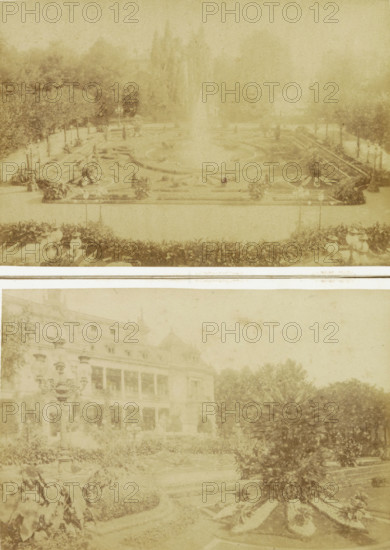 Fountain with flower beds in the Palm Garden of Frankfurt, probably seen from the Gesellschaftshaus, Frankfurt a. M. Im Palmengarten, photograph, cabinet photograph, Part of the Palm Garden in Frankfurt am Main., photographer: Johann Friedrich Stiehm, Palmengarten Frankfurt, in or after 1871 - c. 1880, Hessen, Frankfurt am Main, pasteboard, paper, albumen print, height 109 mm x width 168 mm, garden fountain, public gardens, park, botanic garden, 'hortus botanicus', A faded sepia-toned image shows a formal garden scene with a large central fountain spraying upward, surrounded by patterned flowerbeds and low hedges; lamp posts and decorative urns line the pathways, and a row of trees forms a backdrop behind the fountain; in the lower portion a grand building with multiple stories and balconies is partially visible, flanked by ornate street lamps and dense shrubbery, and the foreground contains various planted beds and a rounded cluster of spiky-leaved plants.