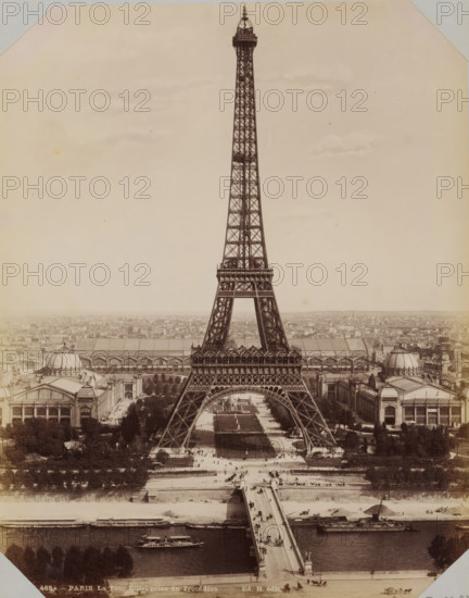 View of the Eiffel Tower, album cover, photograph, This photo is part of an album., retailer's mark: 'E. Hautecoeur, Estampes Photographies, 35 Avenue de l'Opéra, 35, Paris', inscription: '468A - Paris. La Tour Eiffel prize de Trocadéro. Ed. H. édit', photographer: Edouard Hautecoer (possibly), Paris, 1890 - 1898, paper, albumen print, height 258 mm x width 355 mm, city-view in general, 'veduta' (city(-scape) with figures, staffage), Eiffel tower, A tall iron lattice tower dominates the center of the image, rising from a wide base with four arched legs and tapering to a narrow pinnacle with an observation platform near the top; beneath the tower a broad formal garden with walkways and rectangular lawns stretches toward a bridge that crosses a river in the foreground where several boats are moored and one is underway; flanking the tower on both sides are large exhibition halls with domed roofs and arched colonnades, and rows of trees and avenues line the avenues and spaces around the bu...