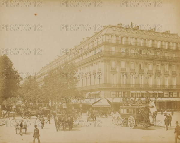 View of the Boulevard des Capucines with horse-drawn trams and the Grand Hotel in Paris, photograph, Part of a travel album with photographs of sights in Sweden, Norway, Denmark, Bavaria, Milan, and Paris., Paris, c. 1870 - c. 1890, photographer, paper, albumen print, height 220 mm x width 278 mm, street, hotel, hostelry, inn, four-wheeled, animal-drawn vehicle, eg: cab, carriage, coach, A wide street scene showing a large multi-story corner building with rows of tall windows and shuttered upper windows, ornate balconies, and a sloped mansard roof with chimneys and rooftop railings, trees lining the street in front of the building, horse-drawn carriages and coaches moving along the roadway, a double-decker horse bus with an open upper deck, people walking and standing on the pavement and near the vehicles, awnings extending from the ground floor of the building, decorative architectural details on the building facade, and a hazy sky above.