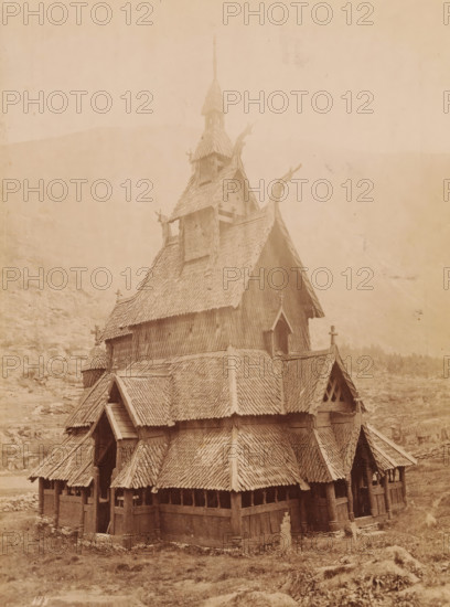 View of the Borgund Stave Church in Norway, photograph, inscription: 'Norge, Borgundskirke i Laerdal, Sogn.', Borgund, 1860 - 1900, photographer, Sogn og Fjordane, pasteboard, paper, albumen print, height 179 mm x width 134 mm, height 300 mm x width 245 mm, the Christian Churches, Borgund Stave Church, A multi-tiered wooden building with steep, shingled roofs and ornate carved roof ridges fills the frame, showing layered gables, small arched windows, and open arcaded walls supported by wooden posts; the upper tower rises to a pointed spire with additional small roofed openings and carved finials, while the lower sections display overlapping shingle patterns, entrance porches beneath pitched roofs, and weathered wooden surfaces; the structure sits on a grassy, rocky landscape with faint hills visible in the background under a pale sky.