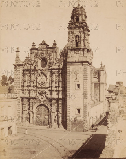 Iglesia de la Santisima, La Santisima Church, View of the Iglesia de la Santísima in Mexico City, Mexico, photograph, copyright notice: 'es-propriedad, depositada 25 marzo 1896.', number: 'N. 121', photographer: Abel Briquet, Mexico City, 1896, North America, pasteboard, paper, albumen print, height 194 mm x width 133 mm, height 210 mm x width 161 mm, Roman Catholic Church, Iglesia de la Santísima, A sepia-toned photograph shows a richly ornamented stone church facade with an elaborate carved main entrance flanked by decorative columns and sculpted figures, a large ornate window above the doorway, and a tall bell tower rising to the right with arched openings and a visible bell; the street in front has tram tracks and a few small figures near the entrance, a horse tied along the building at the right, and parts of adjacent walls and rooftops visible along the sides.