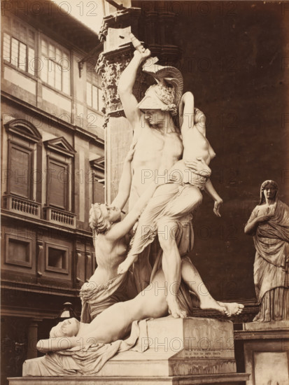 Ratto di Polissena del Fedi, Sculpture The Robbery of Polyxena by Pyrrhus by Pio Fedi in the Loggia dei Lanzi in Florence, Italy, Firenze, photograph, Firenze., number: '3081', address: 'GIACOMO BROGI, FOTOGRAFO-EDITORE, FIRENZE, LUNC ARNO DELLE GRAZIE 19', photographer: Giacomo Brogi, Florence, after sculpture by Pio Fedi, 1866 - 1881, Pio Fedi, after sculpture by, Tuscany, pasteboard, paper, albumen print, albumendruk, height 469 mm x width 344 mm, piece of sculpture, reproduction of a piece of sculpture, Toscane, Loggia dei Lanzi, A sepia-toned photograph of a large classical marble sculpture group showing a muscular male figure wearing a crested helmet raising an arm and holding a weapon, his other arm supporting a limp female figure whose head tilts back and whose draped clothing falls in folds, while other entwined figures reach up and cling to them; the scene stands on a carved pedestal in front of a column with ornate capital and a dark architectural recess, with a multi-window...