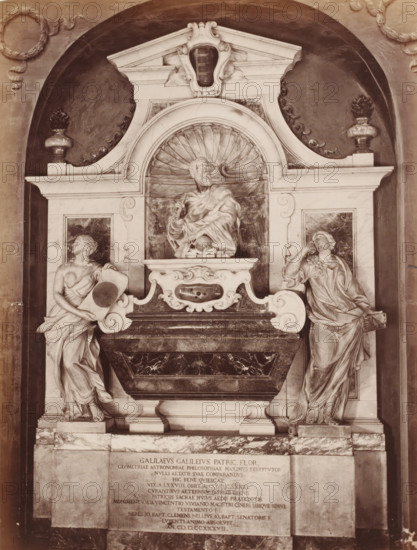 Sepulchral monument to Galileo Galilei in the Santa Croce in Florence, Italy, Tomba di Galileo S. Croce, Firenze, photograph, address: 'GIACOMO BROGI, FOTOGRAFO-EDITORE, FIRENZE, LUNG ARNO DELLE GRAZIE 15', number: '3136.', photographer: Giacomo Brogi, Florence, publisher: Edizioni Brogi, after sculpture by various manufacturers, 1864 - 1881, various manufacturers, after sculpture by, Tuscany, pasteboard, paper, albumen print, height 471 mm x width 350 mm, Person, Galileo Galilei, piece of sculpture, reproduction of a piece of sculpture, grave-building, monumental tomb, Santa Croce, A sculpted stone monument set into a recessed arched niche features a central marble sarcophagus with a richly veined dark front and ornate carved white supports, surmounted by a semicircular shell niche containing a seated bearded male figure draped in flowing robes holding an object near his chest, flanked on either side by two standing female figures in classical drapery each posed on pedestals with one ...