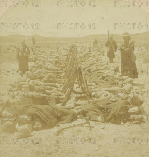 British soldiers sleeping next to their guns near Colesberg, South Africa, 'When the Cannon's roar is still'-sleeping by their Arms (Dec. 30th) before Colesberg, stereograph, copyright notice: 'Copyright 1900 by Underwood & Underwood.', inscription: 'SUN SCULPTURE, UU, TRADEMARK, Works and Studios, Arlington, NJ Westwood, NJ Washington, DC', inscription: ''When the Cannon's roar is still'-sleeping by their Arms (Dec. 30th) before Colesberg, South Africa.', Colesberg, publisher: Underwood and Underwood, New York (city) (possibly), 1900, photographer, North America, pasteboard, paper, albumen print, height 88 mm x width 178 mm, the soldier, the soldier's life, Second Boer War (1899-1902), A sepia-toned scene shows a wide flat landscape with low hills in the distance and a sky taking up the upper portion of the image, a long row of rifles propped muzzle-up forming a central line that recedes toward the horizon, flanked on both sides by numerous figures lying on the ground covered with bla...