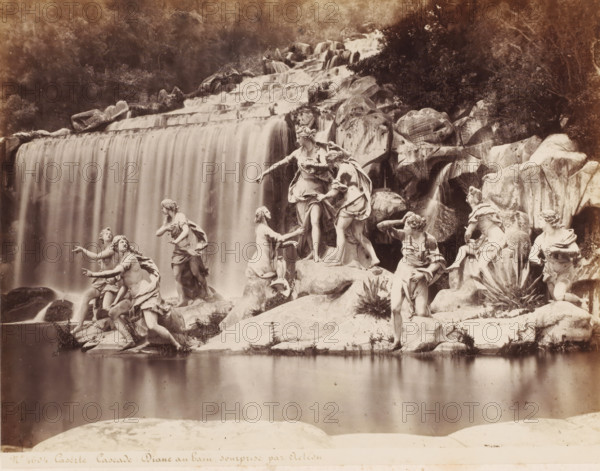 Caserta Cascade: Diane au bain sourprise par Acteon, Fountain of Diana and Actaeon in the gardens of the Palace of Caserta, Italy, photograph, number: 'No. 4604', number: '13', inscription: 'Sommer (+)', photographer: attributed to Giorgio Sommer, Caserta, after sculpture by various manufacturers, 1857 - 1914, various manufacturers, after sculpture by, Attributed to, pasteboard, paper, albumen print, albumendruk, height 307 mm x width 404 mm, ornamental fountain, Palace of Caserta, A wide scene of a cascading waterfall flowing over layered rock ledges into a calm pool in the foreground, with carved marble statues of human figures arranged on rocks at the water's edge; the statues show varied poses and draped clothing, some standing, some kneeling, and some reaching outward, with detailed facial features and flowing hair; large rounded boulders and textured rock surfaces surround the sculptures, and vegetation appears in patches among the rocks and near the water; the upper background s...