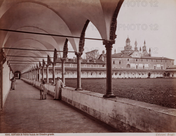 Veduta del Chiostro grande, Monastery with three monks in Pavia, Italy, Certosa di Pavia, photograph, number: '4645.', number: '13', photographer: Giacomo Brogi (possibly), Pavia (city), publisher: Edizioni Brogi, Florence, 1856 - 1881, Tuscany, Lombardy, pasteboard, paper, albumen print, height 303 mm x width 405 mm, monk(s), friar(s), cloisters, monastery, A long covered arcade with a row of tall, rounded arches supported by columns runs along a paved corridor beside an open grassy courtyard, ornate column capitals and decorative arch moldings visible, with a large multi-towered building and domed structure rising beyond the far side of the courtyard; three robed figures stand along the corridor near the balustrade, two facing toward the camera and one further down the walkway, and horizontal beams span between the arches overhead.