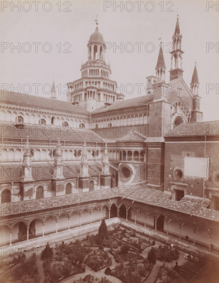 Monastery garden and tower of the Certosa di Pavia in Pavia, Italy, Flanco della Chiesa, Certosa di Pavia, photograph, number: '13', inscription: 'Brogi (t)', number: '3853 ?', Pavia (city), publisher: attributed to Giacomo Brogi, Florence, 1856 - 1881, photographer, Tuscany, Lombardy, Attributed to, pasteboard, paper, albumen print, height 402 mm x width 307 mm, courtyard, parts of church exterior and annexes: tower, cloisters, monastery, A sepia-toned photograph showing a large historic brick building with multiple tiled roofs and ornate architectural details, including a central multi-tiered dome with columns and balustrades, and several tall pointed spires with decorative tops; a cloister with arched walkways and columns surrounds a rectangular garden with pathways and planted beds, and the exterior walls feature round and arched windows, decorative cornices, and sculpted elements.
