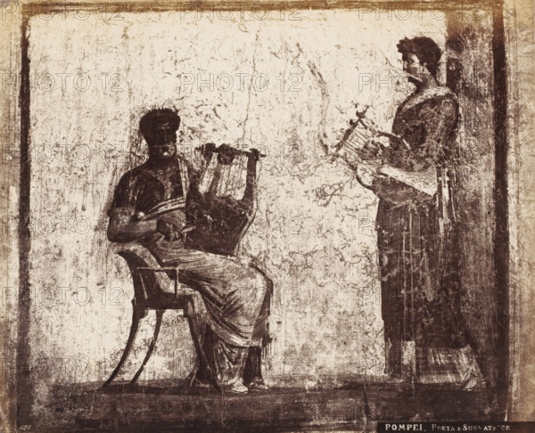 Poeta e Suonatrice, Photographic reproduction of a fresco depicting two people playing a lyre, Pompeii, photograph, reproduction, number: '11', number: '121', number: '77', after painting by anonymous, 1851 - 1900, photographer, pasteboard, paper, albumen print, height 198 mm x width 243 mm, picture, painting, wall-covering, A textured, worn mural shows two robed figures against a pale, scratched background enclosed by a darker border; one figure sits in a curved-back chair holding a lyre-like instrument across their lap while the other figure stands facing them holding a similar stringed instrument, both rendered in dark, sketchy lines with draped clothing and indistinct facial features, and the scene has an overall aged, sepia-toned appearance.