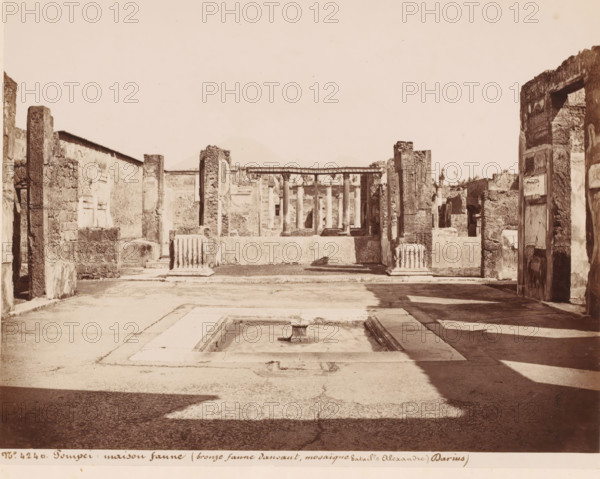 Ruin of the House of the Faun in Pompeii, Italy, Maison faune (bronze faune dansant, mosaïque bataille Alexandre Darius), Pompeii, photograph, number: '36.', number: '10', number: 'No. 4240.', photographer: attributed to Giorgio Sommer, 1857 - 1875, Attributed to, pasteboard, paper, albumen print, height 307 mm x width 405 mm, ruin of a dwelling, house, castle, excavation, archaeology, Casa del Fauno, A sunlit ruinous courtyard with stone walls and remnants of columns framing a central rectangular basin with a small square pedestal at its center, flanked by broken column drums and low masonry platforms, a colonnade visible beyond with tall slender columns supporting a horizontal entablature, rough textured walls and doorways opening to inner chambers on either side, scattered architectural fragments and shadowed paving across the foreground, and a faint outline of a distant conical hill against a pale sky.