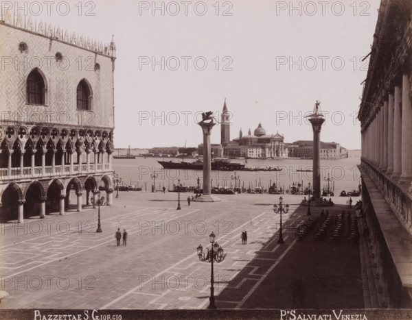 Piazzettae S. Giorgio, View of the square of the Chiesa di San Giorgio Maggiore towards the campanile of San Marco in Venice, photograph, inscription: 'Venetie', photographer: Paolo Salviati, Venice, 1860 - 1870, pasteboard, paper, albumen print, height 196 mm x width 251 mm, height 275 mm x width 364 mm, city-view in general, 'veduta', square, circus, Isola di San Giorgio Maggiore, Chiesa di San Giorgio Maggiore, A wide stone promenade bordered by ornate buildings opens toward a body of water where boats are moored and a domed church and campanile rise on the opposite shore; two tall columns topped with statues stand near the waterfront between the square and the water; on the left a palatial façade shows arched colonnades, decorative windows, and patterned stonework while on the right a long arcade of columns casts a deep shadow over rows of empty chairs and tables; ornate street lamps line the paved square where a few pedestrians are walking and small groups stand near the water’s e...