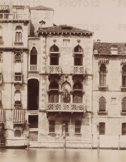 Palazzo Contarini Fasan, Façade of the Palazzo Contarini Fasan in Venice, Italy, Venezia, photograph, number: '64', Venice, 1851 - 1900, photographer, pasteboard, paper, albumen print, albumendruk, height 368 mm x width 318 mm, canals, waters (in city), facade (of house or building), A tall façade of connected old buildings rises from a calm canal, showing weathered stone and brick walls with decorative balconies and arched windows; ornate carved balustrades and pointed arch openings appear on the central section, with two small columns flanking a darker arched entrance near the waterline and a pair of striped poles standing in the canal; adjacent sections display shuttered and open windows with fabric awnings, stone cornices and tiled roofs, and areas of peeling plaster and exposed brickwork.