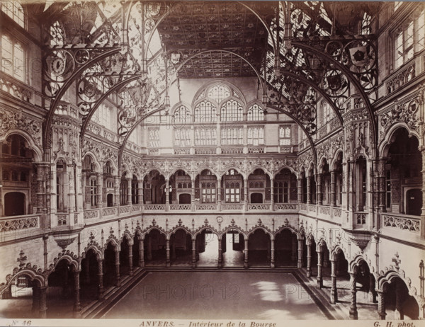 Interior of the Stock Exchange, Interior of the Stock Exchange in Antwerp, Belgium, Anvers, photograph, number: 'No 46', photographer: Gustave Hermans, Antwerp, 1884 - 1914, paper, albumen print, height 218 mm x width 285 mm, interior, representation of a building, Exchange, Stock Exchange, A large ornate interior space with a high ceiling and tall arched windows, featuring multiple levels of arcaded galleries with carved stone columns and decorative balustrades, elaborate wrought iron or carved wooden supporting arches with circular motifs spanning across the open central area, richly ornamented walls and archways with sculptural reliefs and floral patterns, a broad open floor area bordered by steps and rows of arched openings at ground level, and light streaming in from the upper windows creating patches of brightness on the floor.