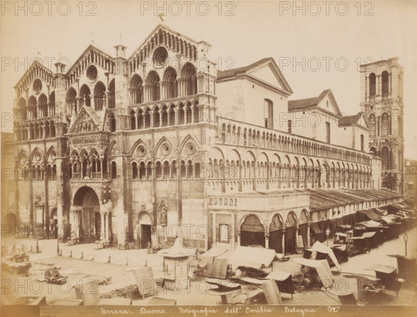 Ferrara, Duomo, View of the west facade of the cathedral in Ferrara and a market in the square, Italy, photograph, photographer: Fotografia dell'Emilia, 1865 - 1907, Fotografia dell'Emilia, pasteboard, paper, albumen print, height 213 mm x width 270 mm, market, church (exterior), Cathedral of Ferrara, A large stone cathedral façade with multiple tiers of arched openings and decorative circular windows dominates the left and center of the image, showing carved figures, columns, and ornate reliefs around entrances and a central pointed gable above a smaller porch. To the right of the façade a long covered arcade with repeating rounded arches extends along the building beside a taller plain structure with a pitched roof and rectangular windows, and further right a tall bell tower with large open arches rises above the complex. In the foreground an open market area spreads across the plaza with many canvas-covered stalls and awnings, scattered goods, a small square kiosk, carts, and low pi...