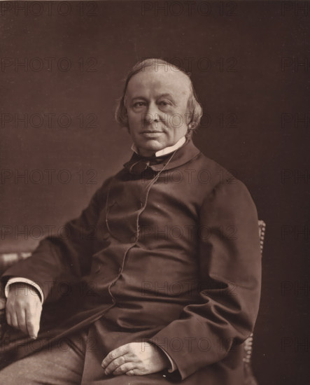 Edouard-Rene Laboulaye, Portrait of Édouard René Lefebvre de Laboulaye, page, photomechanical print, inscription: 'Galerie Contemporaine, 126, boul. Magenta. - Paris., (Né a Paris, le 18 janvier 1811)', photographer: Félix Nadar, cliché maker: Goupil & Cie., 1874 - 1879, paper, Woodburytype, Woodburytypie, height 225 mm x width 185 mm, Person, Édouard René Lefebvre de Laboulaye, historical persons, adult man, A sepia-toned portrait of an older man seated and facing the camera, showing his head, upper torso, and hands; he has a high forehead with thinning hair combed to the sides, light eyebrows, and a calm facial expression with closed lips and visible eyes; he wears a dark, buttoned coat with a high collar and a white shirt collar peeking out, and a narrow ribbon or cord looped at the throat; one hand rests on his lap with fingers relaxed and the other hand rests on the arm of the chair with the cuff of the shirt visible; the background is plain and dark.