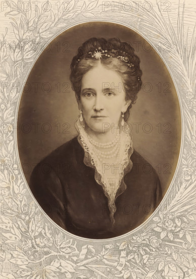 Louise, Queen of Denmark, Photographic reproduction of a painted portrait of Louise, photograph, reproduction, page, after painting by anonymous, c. 1875 - in or before 1880, photographer, paper, albumen print, height 188 mm x width 143 mm, Photo on unnumbered page., Person, Louise Wilhelmina Frederika Caroline Augusta Julia (Queen of Denmark), historical persons - BB - woman, queen, empress, etc. (wife of a ruler), A sepia-toned oval portrait of a woman set against an illustrated floral border shows a middle-aged woman with hair styled up and adorned with a decorative headpiece. She wears drop earrings and multiple strands of pearls around her neck, and a lace-trimmed collar peeks from a dark garment. The background inside the oval is plain and softly shaded, while the surrounding border features detailed line-drawn leaves, flowers, and stems.