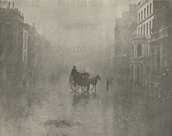 Carriage on the street in London, 'Fine day in London', photomechanical print, photographer: Hector Colard, London, cliché maker: Fillon & Heuse, printer (person): Charles Wittmann, Paris, c. 1891 - in or before 1896, printer (person), paper, photoaquatint, height 144 mm x width 182 mm, mist, fog, street, two-wheeled vehicle drawn by one animal, A foggy street scene in muted tones showing a horse pulling a small carriage with a seated driver, the horse and carriage casting a reflection on the wet pavement, flanked by tall multi-story buildings with visible windows and architectural details, and a few indistinct standing figures partially obscured by the haze.