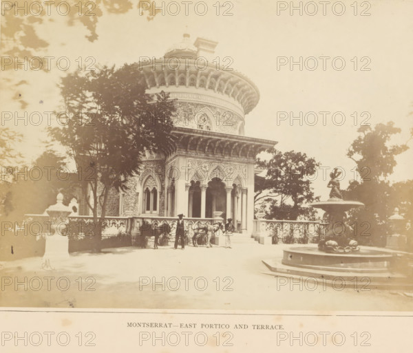 View of the east portico of the Palácio de Monserrate near Sintra, Montserrat - East Portico and Terrace, photograph, page, Sintra, c. 1865 - in or before 1870, photographer, paper, albumen print, height 149 mm x width 200 mm, palace, terrace, gate, entrance, Palácio de Monserrate, A pale, sepia-toned photograph shows an ornate round building with a domed roof and decorative arches, partially obscured by trees in the foreground; the building features carved stone columns, arched windows with tracery, and an overhanging cornice with regularly spaced brackets. In front of the building a balustraded terrace runs along the facade, with a group of people standing near the entrance and a horse present beside them. On the right a multi-tiered fountain with a sculpted figure stands on a raised circular base, and large trees frame the scene on both sides. The overall image has a faded, vintage appearance with soft shadows and scattered foliage.