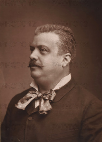 Portrait of Jules Danbé, page, photomechanical print, photographer: Félix Nadar, cliché maker: Lemercier, c. 1880 - c. 1885, paper, Woodburytype, Woodburytypie, height 241 mm x width 174 mm, Person, Jules Danbé, historical persons, conductor, music, A sepia-toned portrait of a middle-aged man shown in three-quarter profile facing left, with short, neatly combed hair and a trimmed mustache; he wears a high, folded white collar, a dark jacket with a buttoned front, and a patterned silk bow tied at the neck.