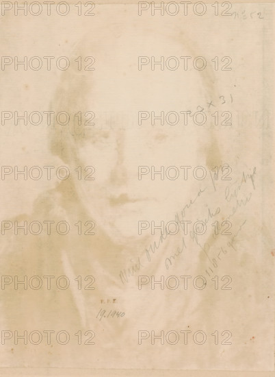 Portrait of an unknown young woman with a bonnet, print, printmaker: Frans Deutmann (signed by artist), 1877 - 1915, paper, monotype, printed in brown, height 326 mm x width 259 mm, anonymous historical person portrayed alone - BB - woman, A faded sepia-toned portrait of a person's face and shoulders is visible, with soft smudged shading and indistinct facial features, the figure wearing a garment with a draped collar and a cloak-like outer layer, the image showing vertical paper texture and scattered small stains and spots across the surface, and faint diagonal scribbled marks along one side.