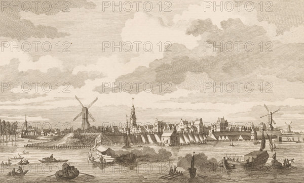 Arnhem seen from across the water, print, 1700 - 1750, printmaker, paper, etching, height 165 mm x width 222 mm, city-view, and landscape with man-made constructions, Arnhem, A wide riverside scene rendered in fine engraving lines shows a town skyline with rows of gabled buildings, spires, and towers along the far bank, punctuated by several windmills with four sails. The foreground features calm water with multiple small boats and barges, some with figures aboard and one larger vessel moored near the shore, while a shoreline with trees, docks, and structures frames the town. Above, a broad sky filled with layered, textured clouds stretches across the scene.