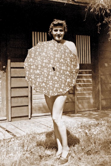 Eva Braun Photo Album Eva Anna Paula Braun (1912 - 1945) is posing with an umbrella. Eva Braun was occasionally seen sun