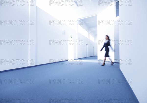 Frau geht ueber Gang eines Buerogebaeudes model released Copyright xMEVx ALLMVAID012AR01