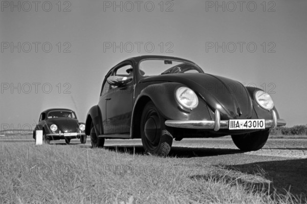 KdF Wagen Zwei Modelle des Volkswagen Käfer, oder KdF Wagen, mit offenem und geschlossenem Dach am Rande einer Teststrec