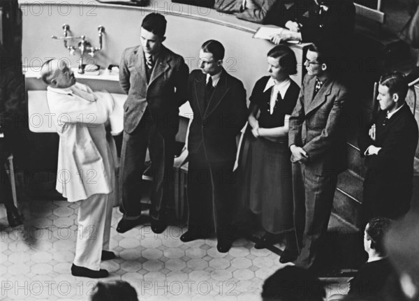 Professor Ferdinand Sauerbruch unterhält sich mit Medizinstudenten im Hörsaal der Charite in Berlin, Deutschland ca. 193