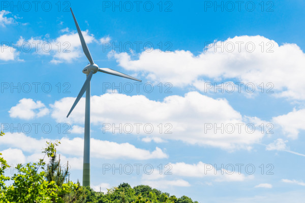 Munich, Bavaria, Germany - 30 May 2025: A large SWM wind turbine is located on the Fröttmaninger Müllberg, generating gr